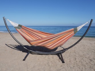 hamac multicolore sur la plage avec un support métallique en arc