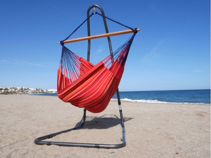 Chaise hamac XXL rouge multicolore avec support métal sur une belle plage