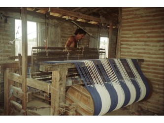 Artisan tissant à la main un hamac sur métier traditionnel, dans un atelier vénézuélien