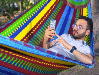 Homme dans un hamac mexicain XXL multicolore  dans le jardin