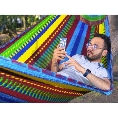 Homme dans un hamac mexicain XXL multicolore  dans le jardin