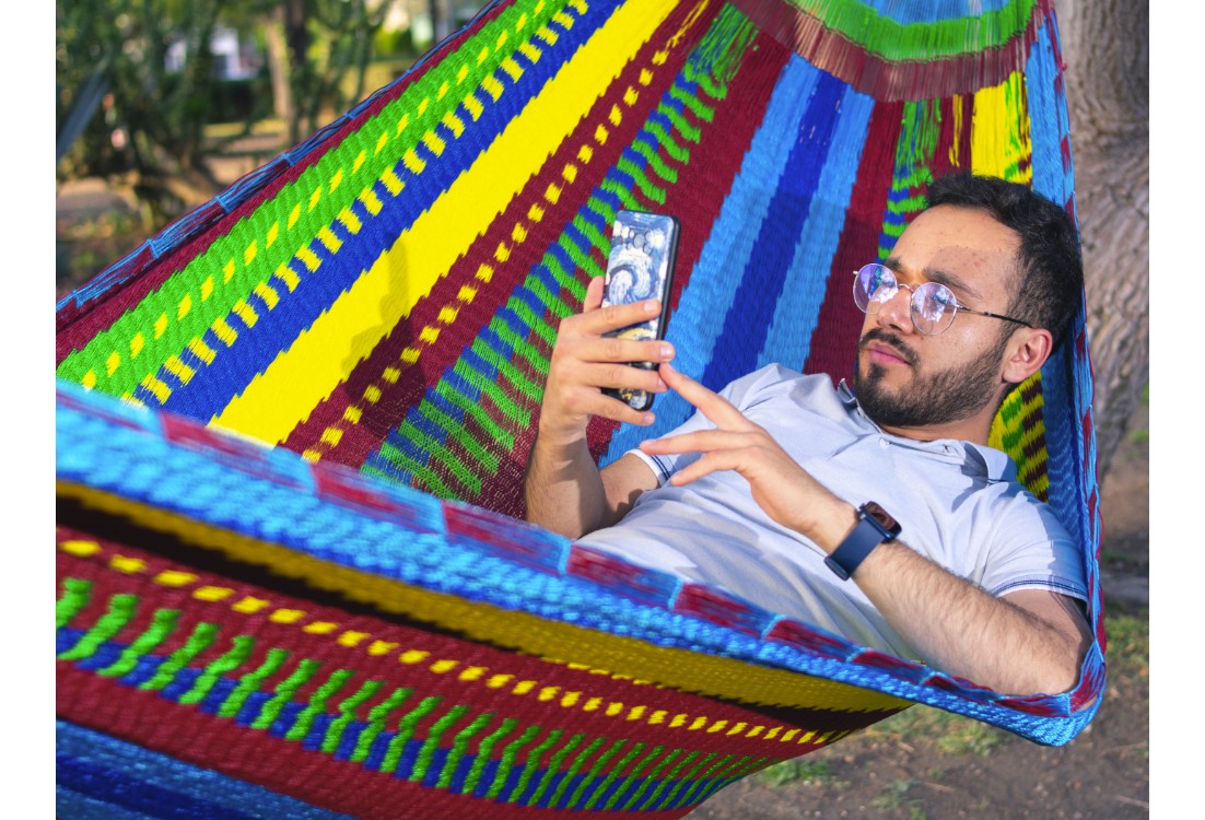 Homme dans un hamac mexicain XXL multicolore  dans le jardin