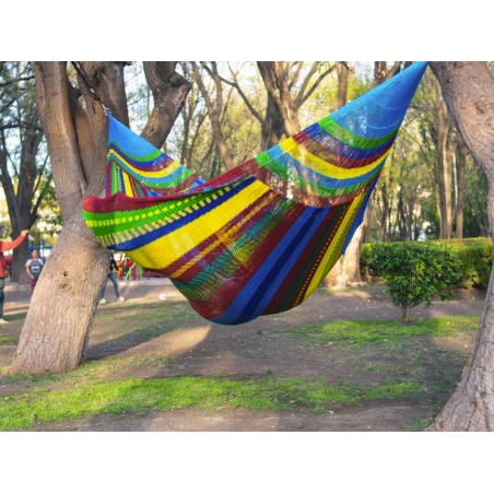 Homme dans un hamac mexicain XXL multicolore  dans le jardin
