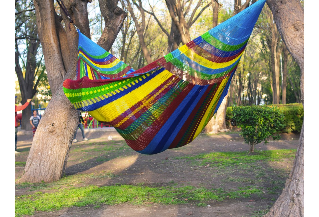 Homme dans un hamac mexicain XXL multicolore  dans le jardin
