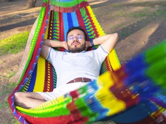 Homme se reposant dans un hamac XXL mexicain multicolore