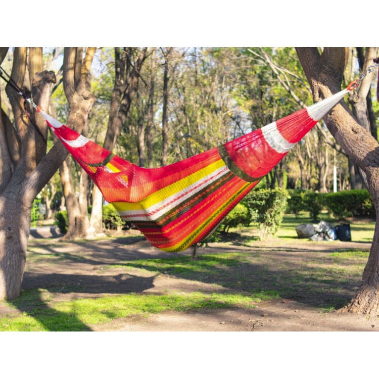 Homme dans un hamac mexicain XXL multicolore  dans le jardin