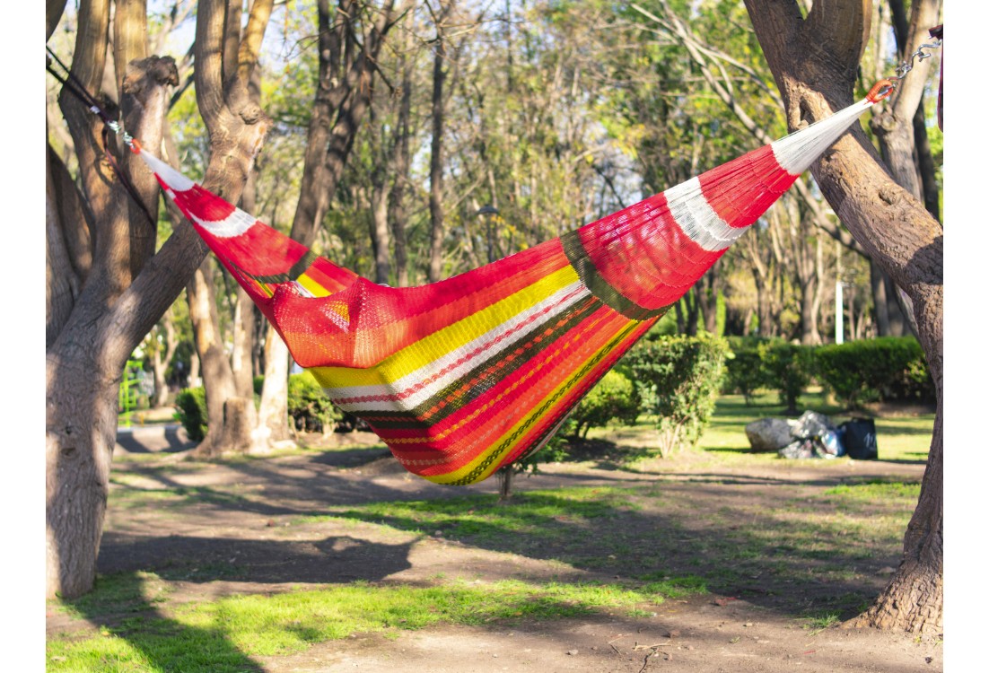 Homme dans un hamac mexicain XXL multicolore  dans le jardin
