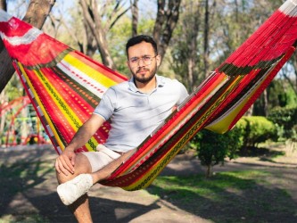 Homme se reposant dans un hamac XXL mexicain multicolore