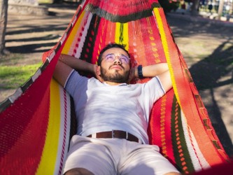 Homme se reposant dans un hamac XXL mexicain multicolore