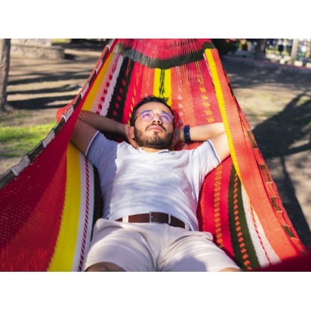 Homme se reposant dans un hamac XXL mexicain multicolore