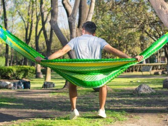 homme assis de dos, dans un hamac mexicain vert