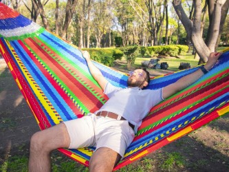 Homme dans un hamac XXL dans le jardin
