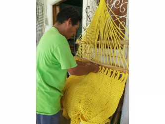Artisan nicaraguayen fabriquant un hamac jaune