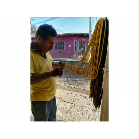 Artisan nicaraguayen fabriquant un hamac jaune dans l'atelier