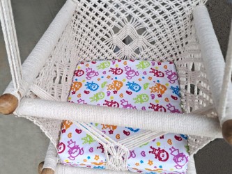 Coussin doux et coloré dans hamac macramé écru pour confort optimal