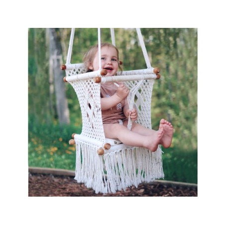 Bébé heureux dans hamac macramé écru suspendu à l’extérieur