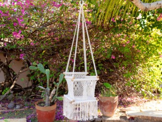 Hamac bébé macramé écru suspendu avec plantes et fleurs colorées