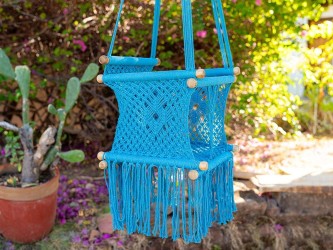 Hamac bébé suspendu en macramé bleu avec coussins colorés, idéal pour le jardin ou l'intérieur
