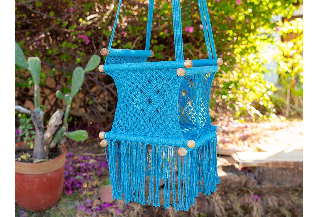 Hamac bébé suspendu en macramé bleu avec coussins colorés, idéal pour le jardin ou l'intérieur