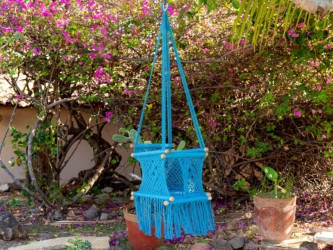 Hamac bébé macramé écru suspendu avec plantes et fleurs colorées