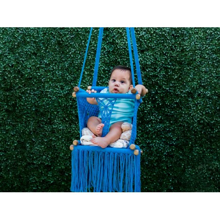Bébé s'amuse dans un hamac suspendu en macramé bleu, sûr et confortable pour une utilisation en extérieur