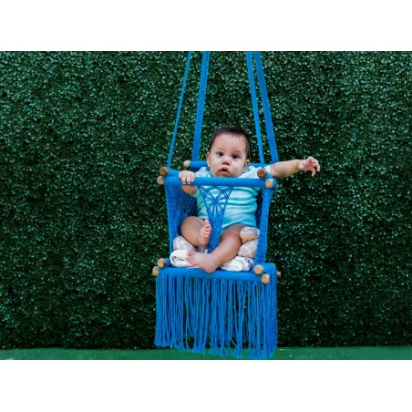 Bébé dans un transat avec un enfant assis, vue de face sur fond vert