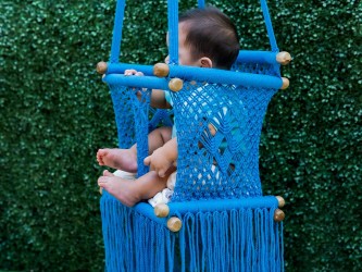 Vue latérale de bébé explorant son environnement depuis le transat. Mouvements doux pour apaiser et divertir