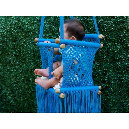 Vue latérale de bébé explorant son environnement depuis le transat. Mouvements doux pour apaiser et divertir