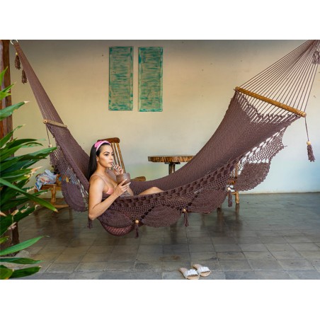 Femme se relaxant dans un hamac à barres chocolat suspendu à l’intérieur