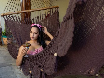 Femme tenant une boisson, assise dans un hamac chocolat artisanal
