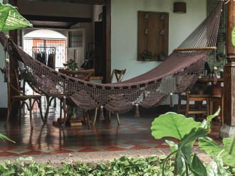 Hamac chocolat suspendu sur terrasse, ambiance tropicale et artisanale