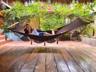 Hamac chocolat suspendu dans un jardin fleuri avec fille