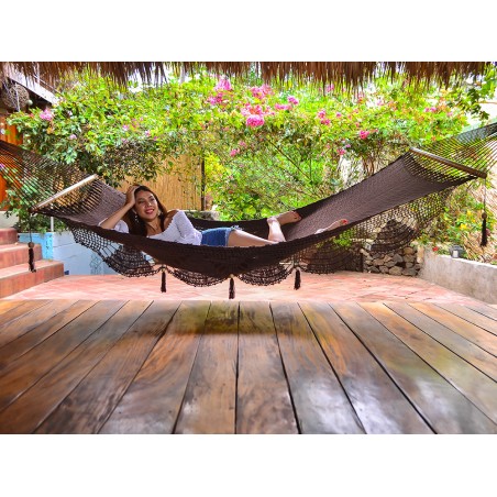 Hamac chocolat suspendu dans un jardin fleuri avec fille