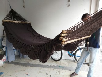Des artisans à l'œuvre pour fabriquer un hamac marron fait à la main