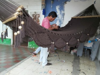 Des artisans à l'œuvre pour fabriquer un hamac marron fait à la main
