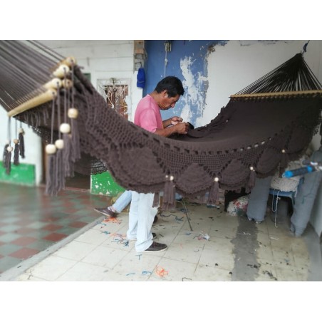 Des artisans à l'œuvre pour fabriquer un hamac marron fait à la main