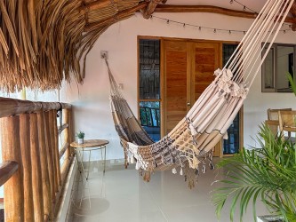 Hamac fait main au design minimaliste dans un espace extérieur avec des plantes et des meubles