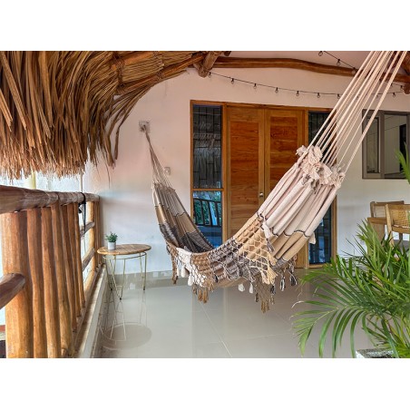 Hamac fait main au design minimaliste dans un espace extérieur avec des plantes et des meubles