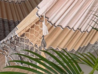 Gros plan d'un hamac vénézuélien tissé à la main avec du feuillage vert, montrant l'environnement naturel