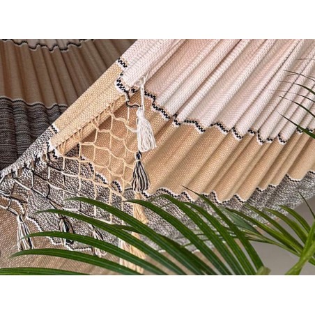 Gros plan d'un hamac vénézuélien tissé à la main avec du feuillage vert, montrant l'environnement naturel