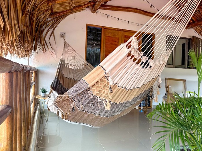 Hamac en coton vénézuélien fabriqué à la main et suspendu sur un porche ou un balcon, style rustique et confortable