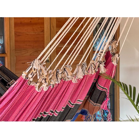 Gros plan sur les cordes et le tissu d'un hamac vénézuélien rose vif