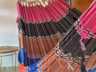 Zoom sur les détails colorés (rose, noir, marron) d'un hamac vénézuélien artisanal