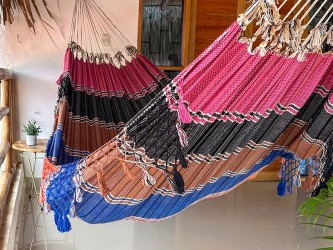 Hamac vénézuélien coloré suspendu dans une pièce, créant un espace de détente joyeux