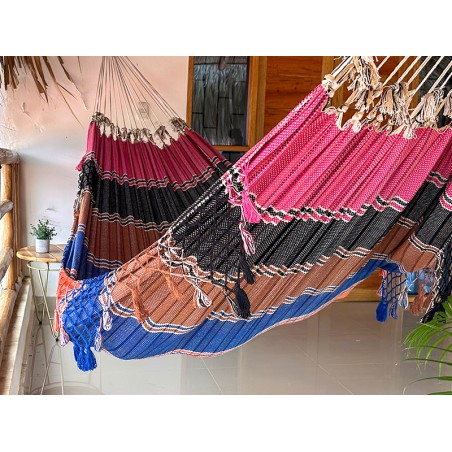 Hamac vénézuélien coloré suspendu dans une pièce, créant un espace de détente joyeux