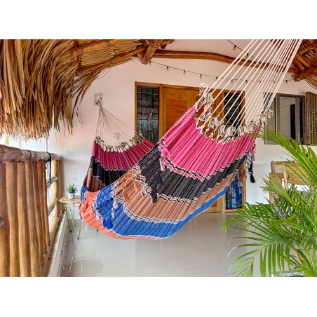 Hamac vénézuélien aux couleurs vives (rose, noir, bleu) suspendu à l'intérieur