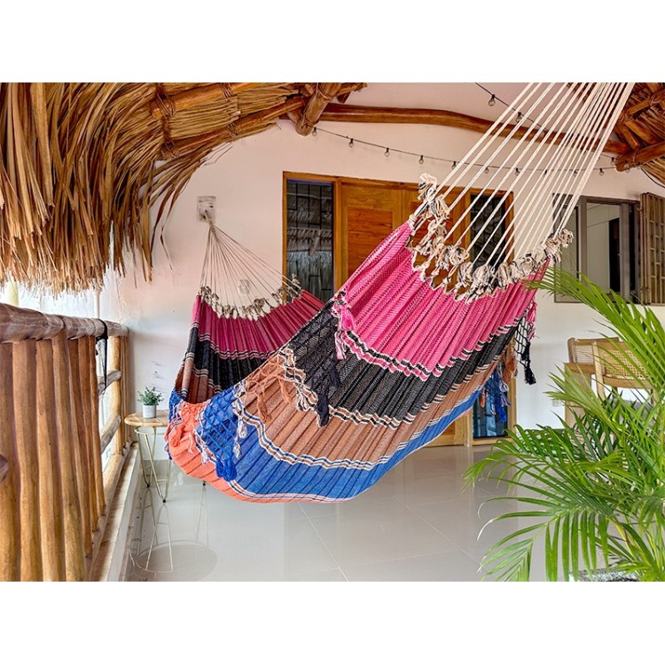 Hamac vénézuélien aux couleurs vives (rose, noir, bleu) suspendu à l'intérieur