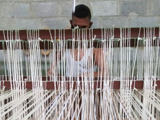 Artisan vénézuélien tissant un hamac coloré sur un métier à tisser traditionnel