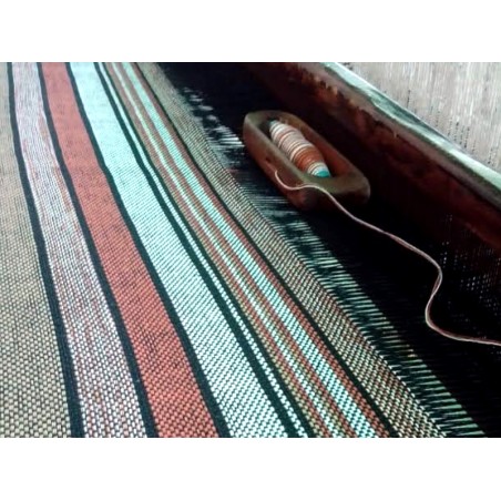 Détail des toiles en cours de fabrication sur métier à tisser traditionnel, montrant la richesse des couleurs