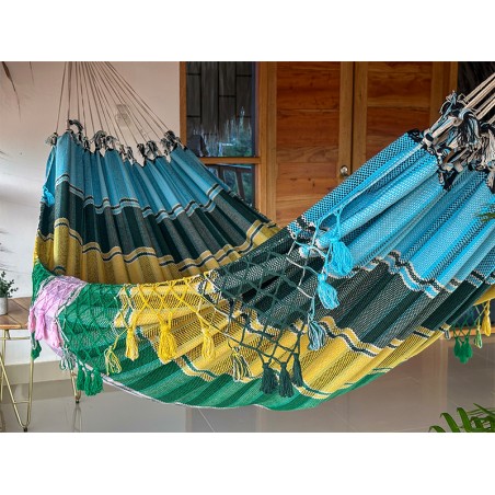 Vue de côté du hamac vénézuélien tissé à la main, suspendu entre deux poteaux sur une terrasse